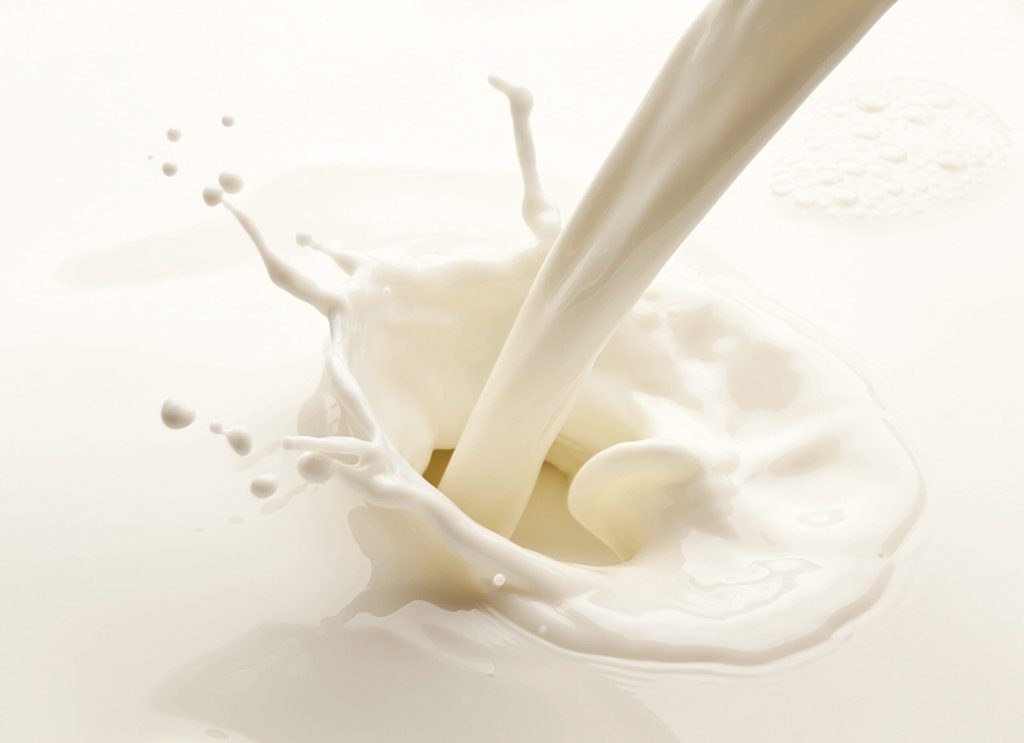 Close-up of creamy white milk being poured with splash effect