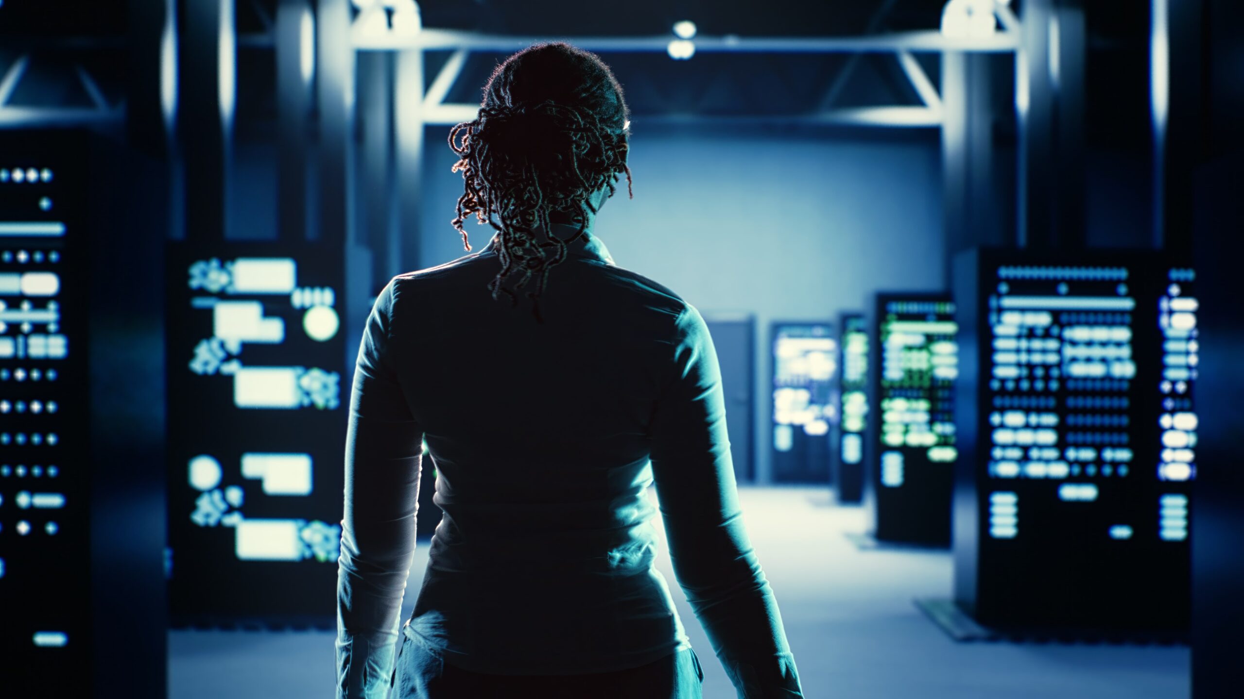 Person standing in a data center surrounded by glowing server racks, symbolizing cloud infrastructure and NOCaaS.
